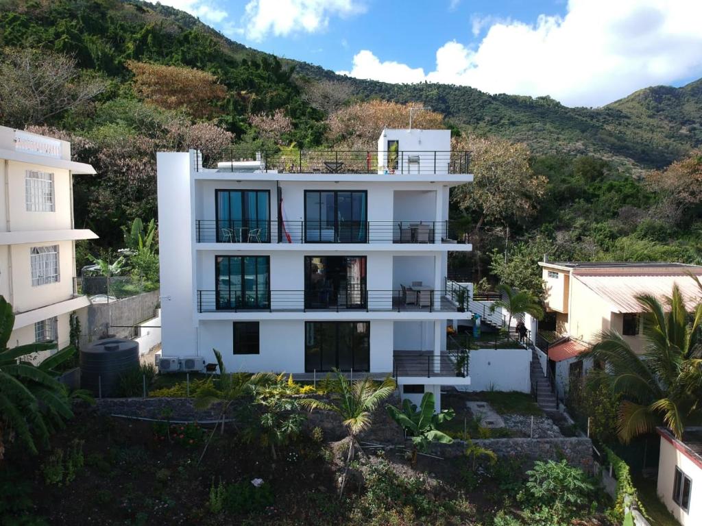 a white house with a hill in the background at Fullmoon Apartment & Studio in La Gaulette