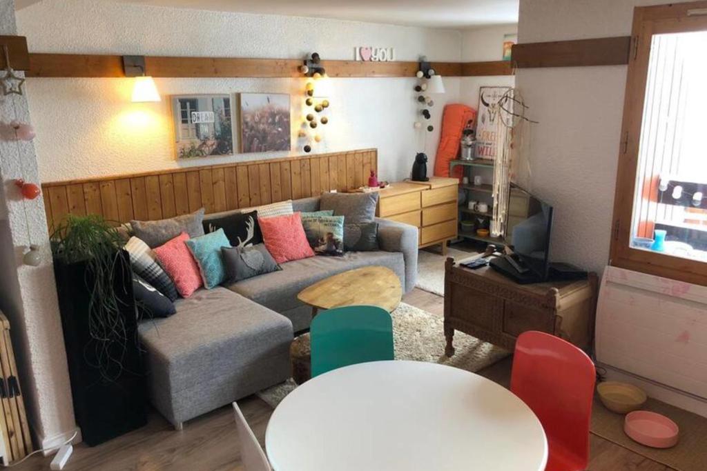 uma sala de estar com um sofá e uma mesa em Modern Apartment In La Plagne 1800 em Mâcot La Plagne