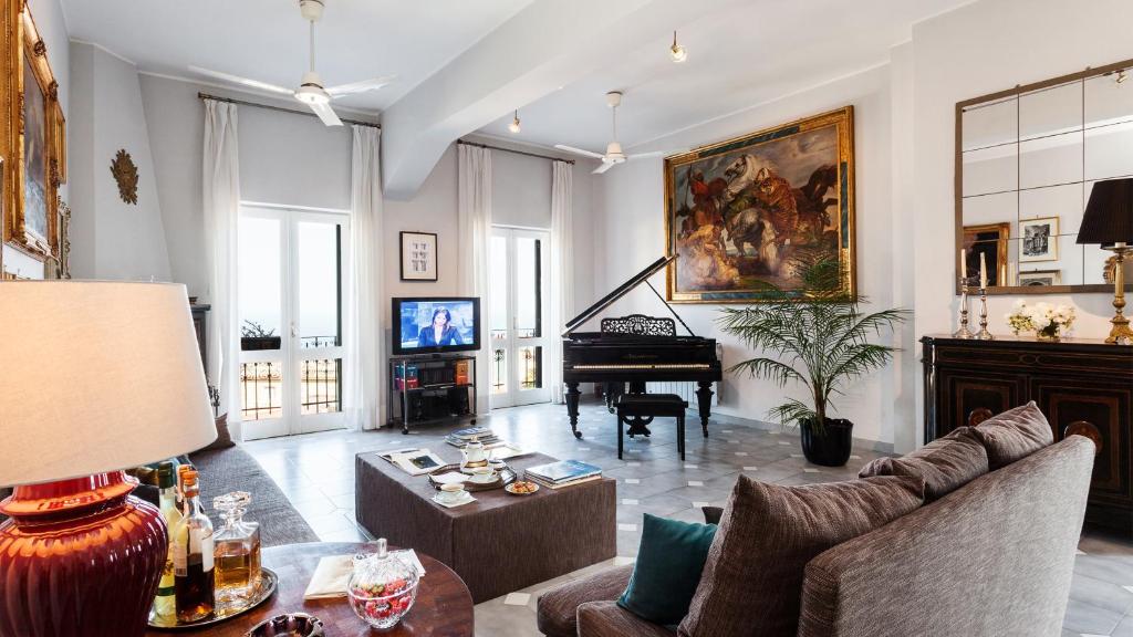 een woonkamer met een bank en een piano bij San Domenico Penthouse in Taormina