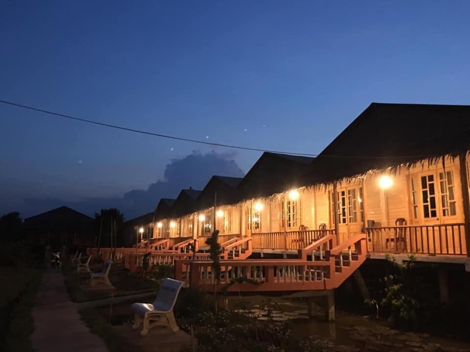 a row of buildings at night with a chair at MEKONG NATURE LODGE in Vĩnh Long
