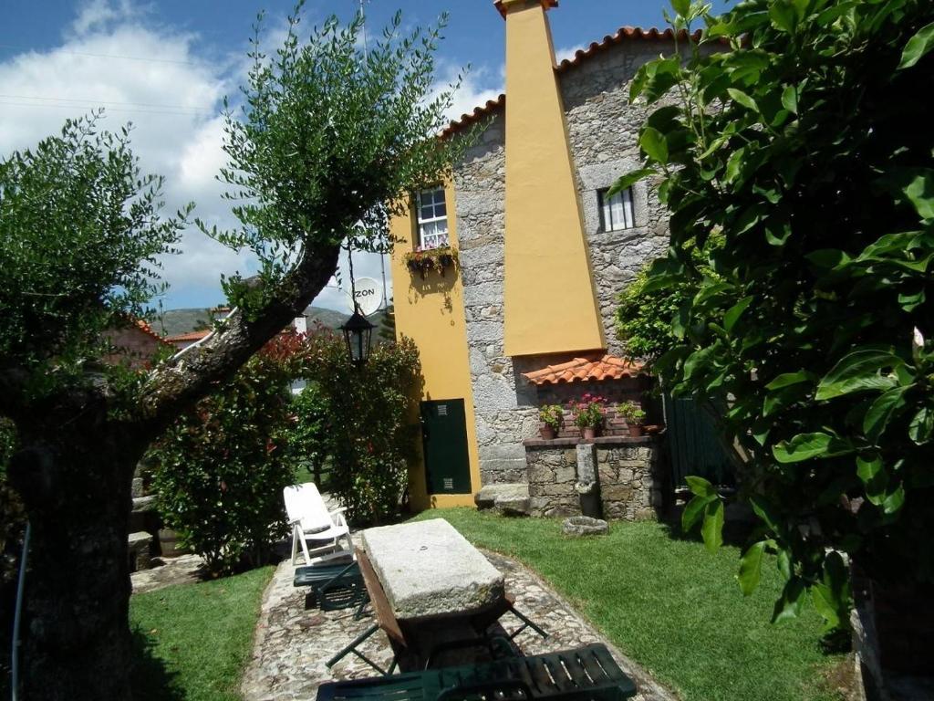 una casa con mesa y sillas en el patio en Casa Rosinha Menor, en Riba de Âncora