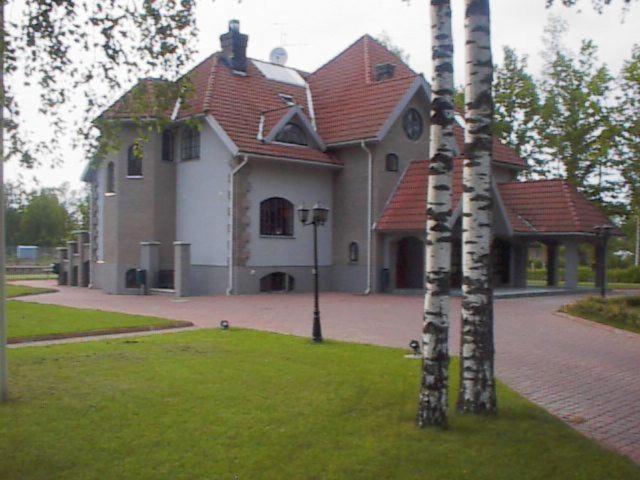 uma casa grande com telhado vermelho em Hotell De Tolly em Tõrva