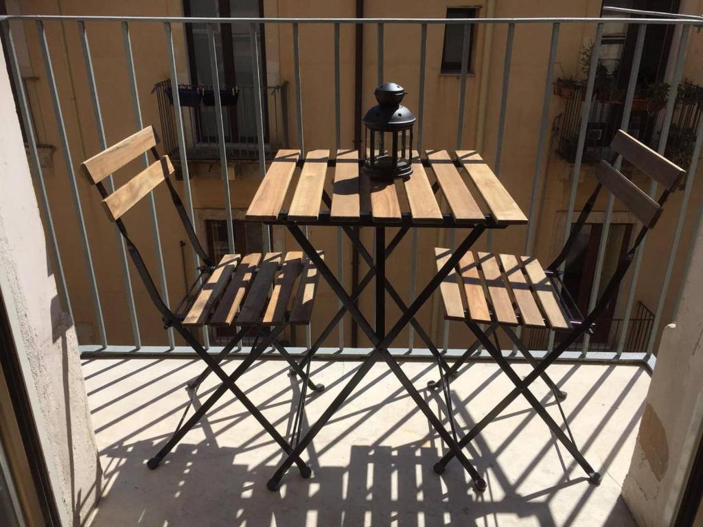 einen Tisch und zwei Stühle auf dem Balkon in der Unterkunft Katane Apartment One-Room in Catania