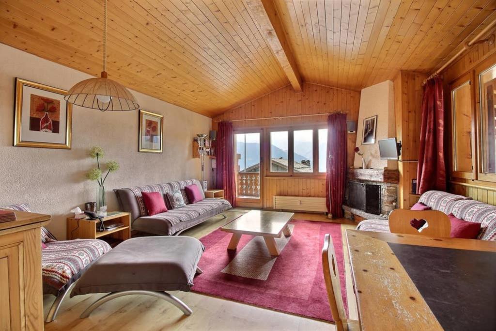 una sala de estar con sofás y techo de madera. en Clair Abri 104, en Verbier
