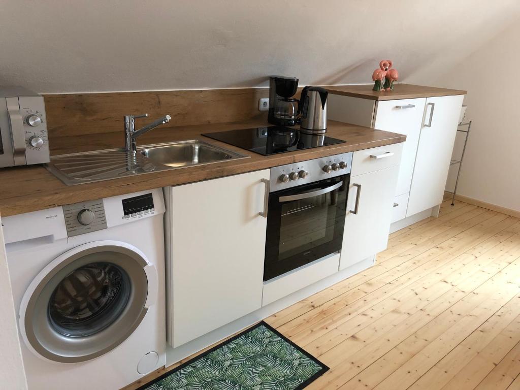 a kitchen with a sink and a washing machine at Ferienwohnung 3 zwischen Nürnberg und Regensburg in Deining