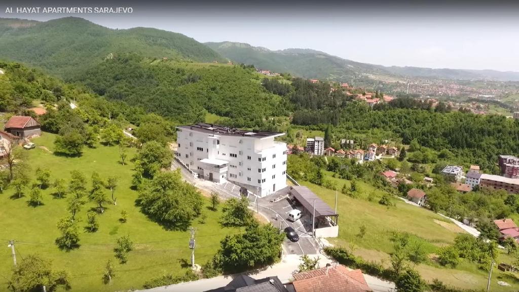 an aerial view of a building on a green field at Al Hayat Apartments in Vogošća