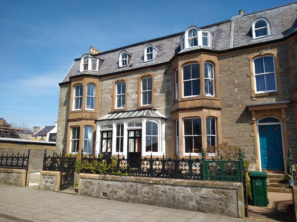 una gran casa de ladrillo con puerta azul en Solheim Guest House en Lerwick