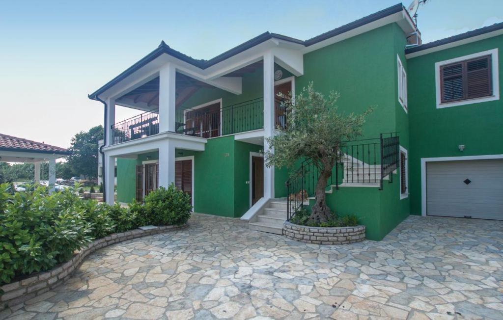 uma casa verde com uma entrada em frente em hostel Stalno Sretan em Labin