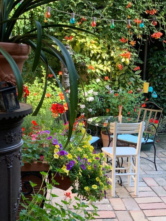 um jardim com mesa, cadeiras e flores em Bed and Breakfast "Caffe-caffe" em Kikinda