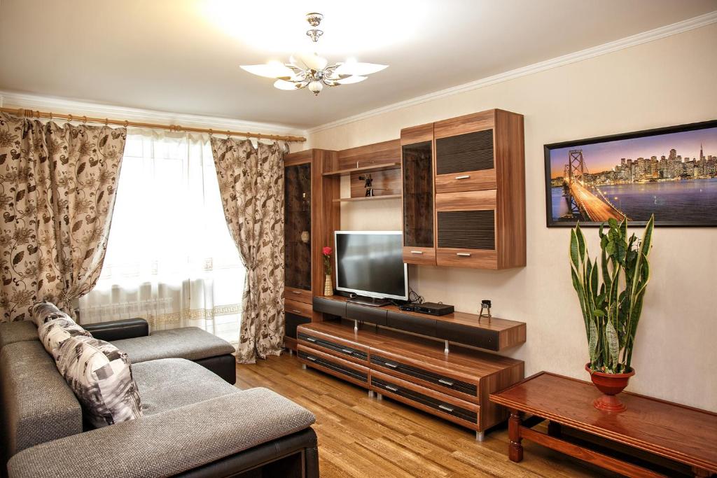 a living room with a couch and a tv at KemHotel Квартирное Бюро in Kemerovo