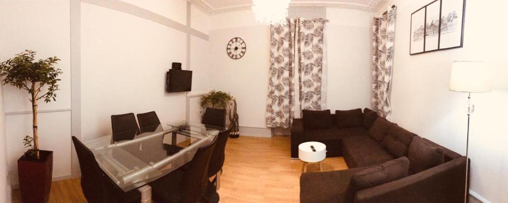 ein Wohnzimmer mit 2 Sofas und einem TV in der Unterkunft LE BRETZEL in Colmar