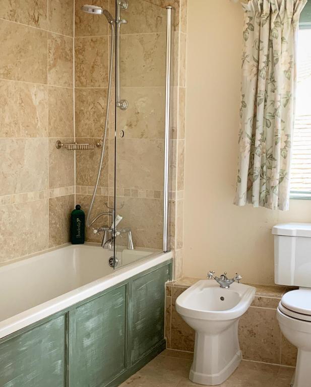 a bathroom with a tub and a toilet and a sink at The Tea House in Rye