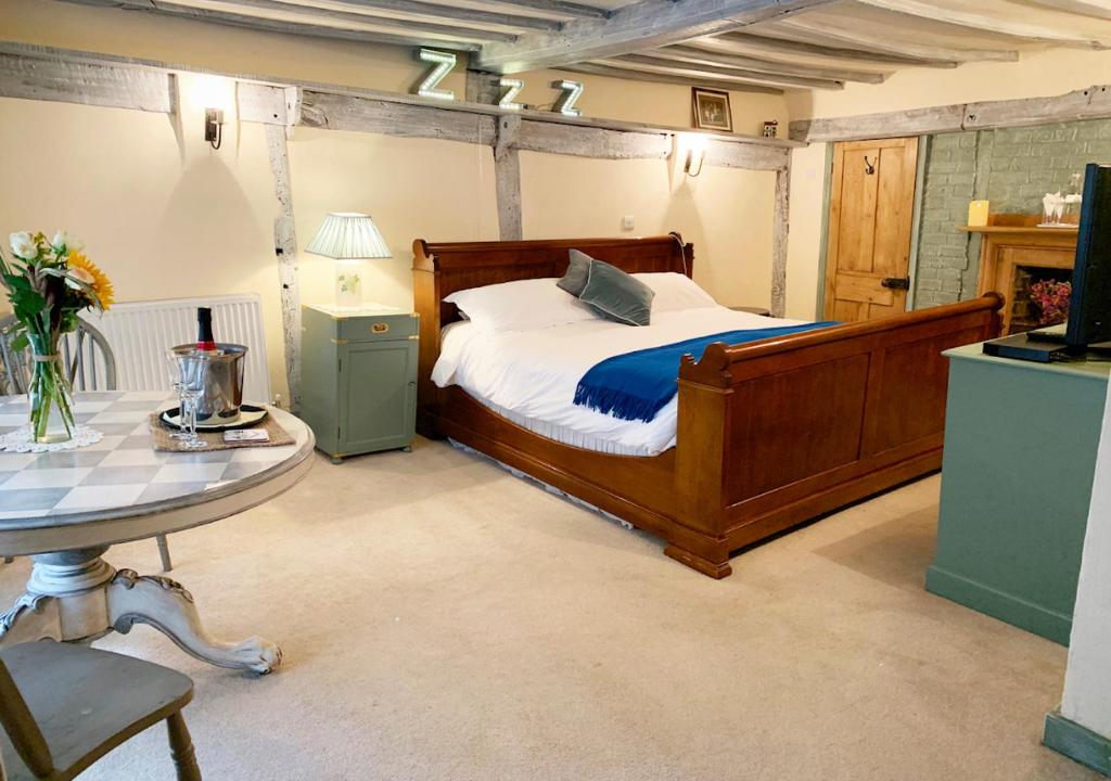 a bedroom with a wooden bed and a table at The Tea House in Rye
