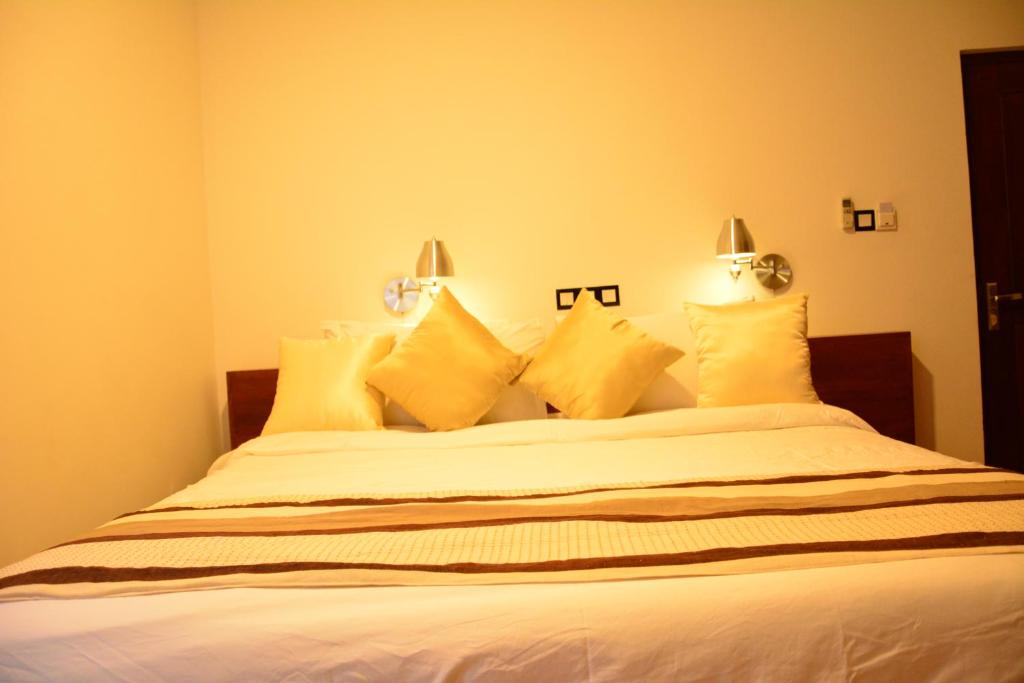 a bedroom with a bed with yellow pillows at Gloria Grand Hotel in Unawatuna