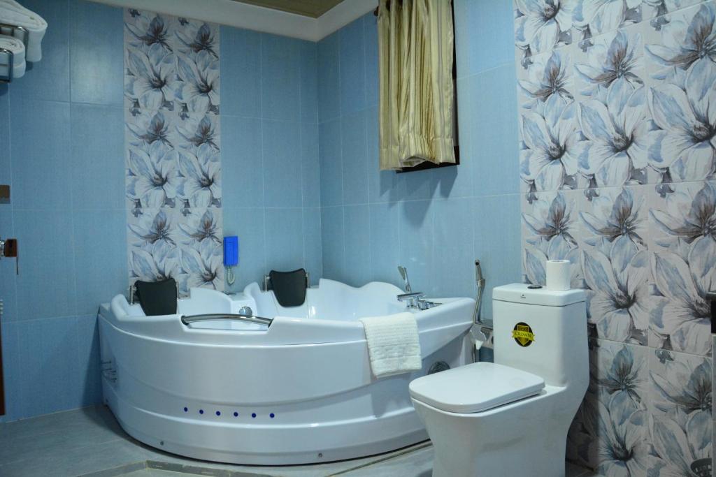 a bathroom with a white toilet and a sink at Gloria Grand Hotel in Unawatuna