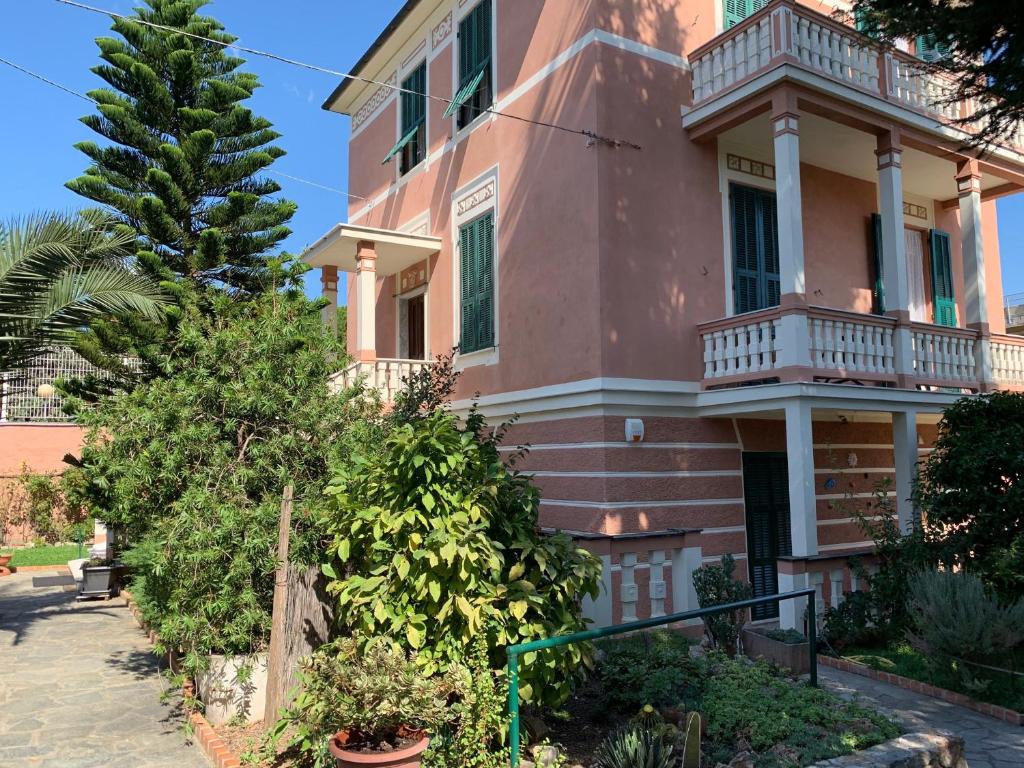 uma casa cor-de-rosa com uma varanda numa rua em Resort Villa Rosa Maria em Savona