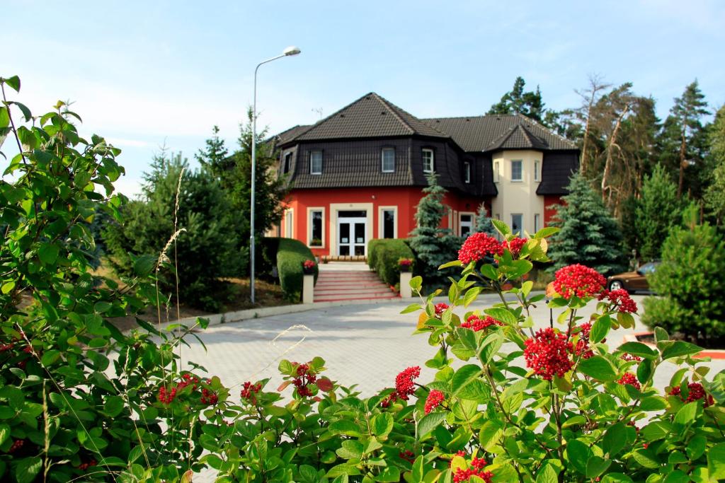 une maison avec des fleurs rouges devant elle dans l'établissement Penzion v Zálesí, à Mladá Boleslav