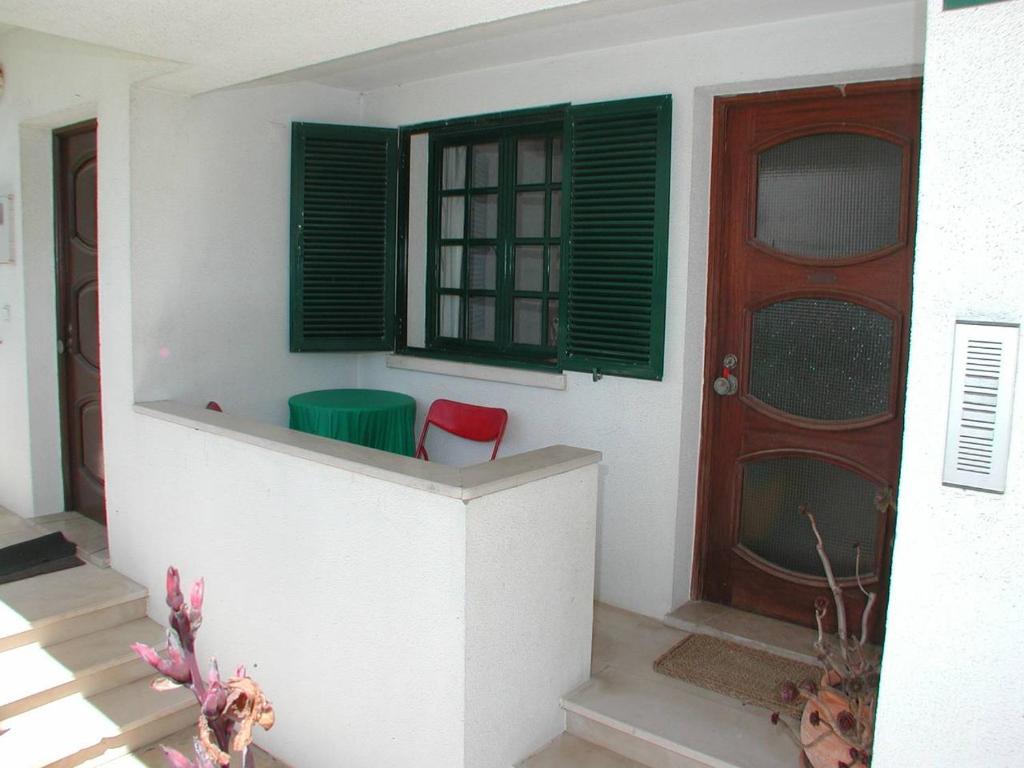 une maison avec une porte et une chaise rouge devant elle dans l'établissement Apartment Wolf, à Lourinhã