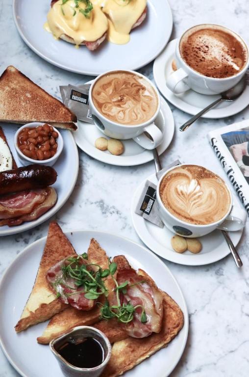 a table with plates of food and cups of coffee at Le Monde Hotel in Edinburgh