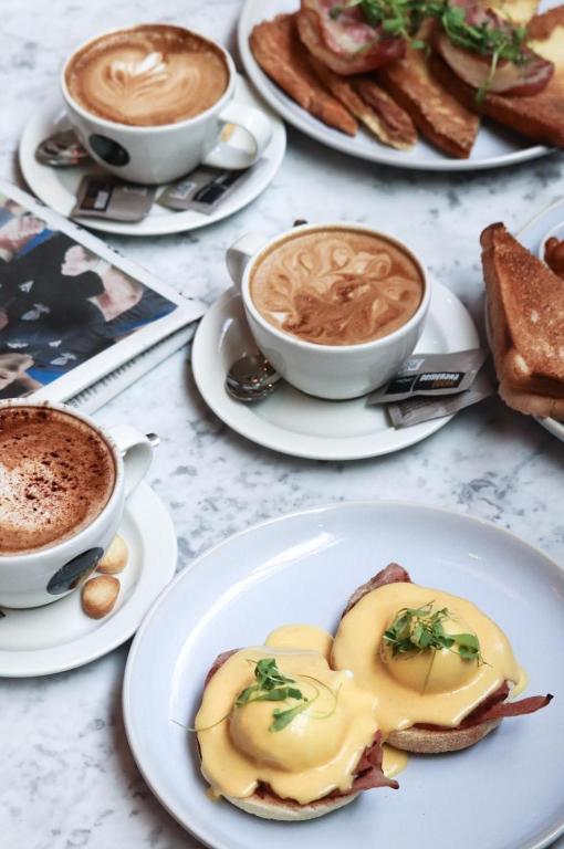 a table with plates of food and cups of coffee at Le Monde Hotel in Edinburgh