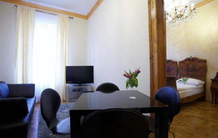 1 dormitorio y sala de estar con mesa y sillas. en Decameron Apartments, en Cracovia