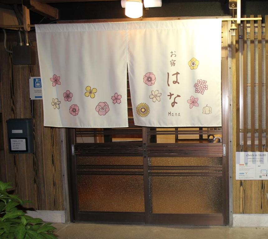 a stage with a white curtain with flowers on it at Oyado Hana in Nachikatsuura