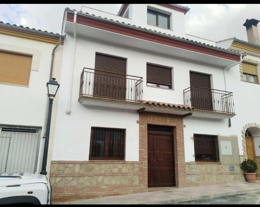 een wit huis met twee balkons en een auto bij Apartamentos Buena Vista 1 in Coto Rios
