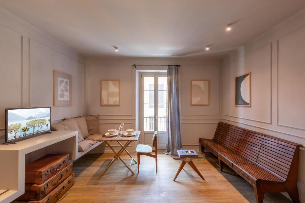 a living room with a bench and a table at Suites Menaggio in Menaggio