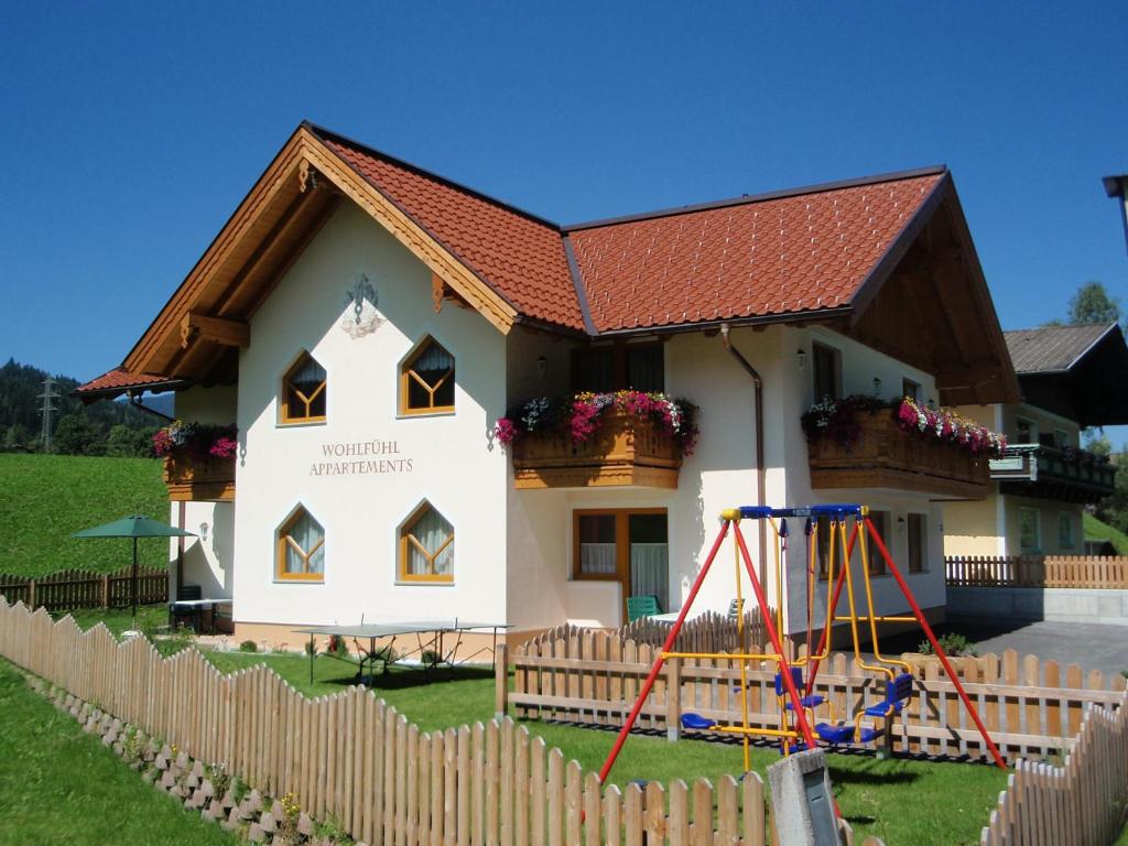 una pequeña casa con un parque infantil delante de ella en Flachauer Bergkristall, en Flachau