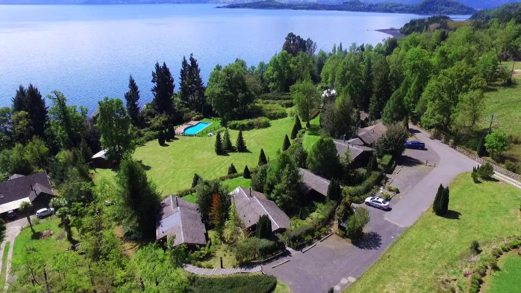 an aerial view of a house on the shore of a lake at Cabañas Portal Pucon in Pucón