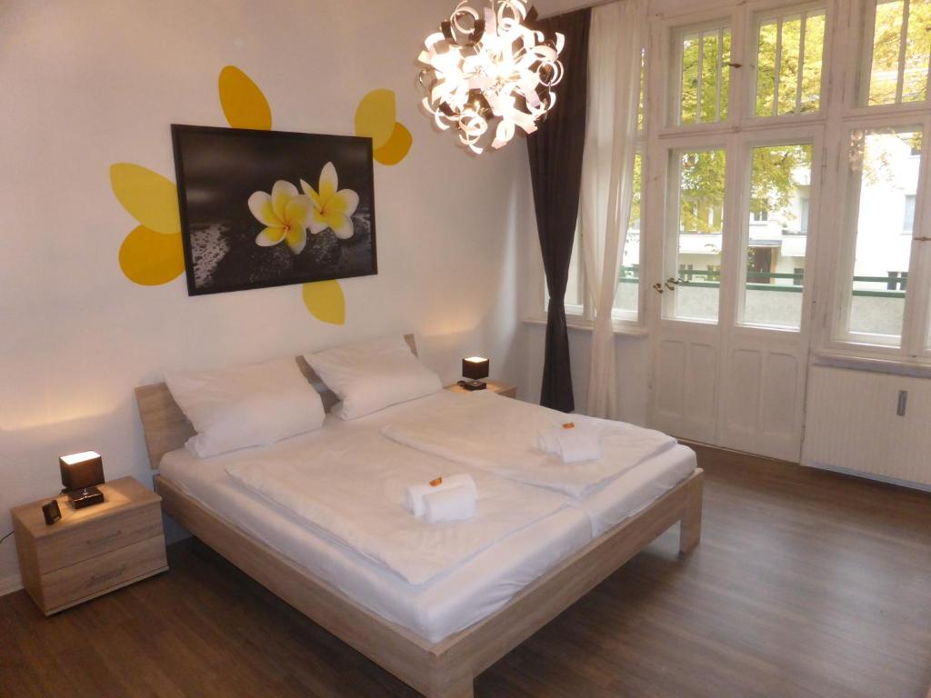 um quarto com uma cama e um lustre em Apartments Dahlie & Nelke em Berlim