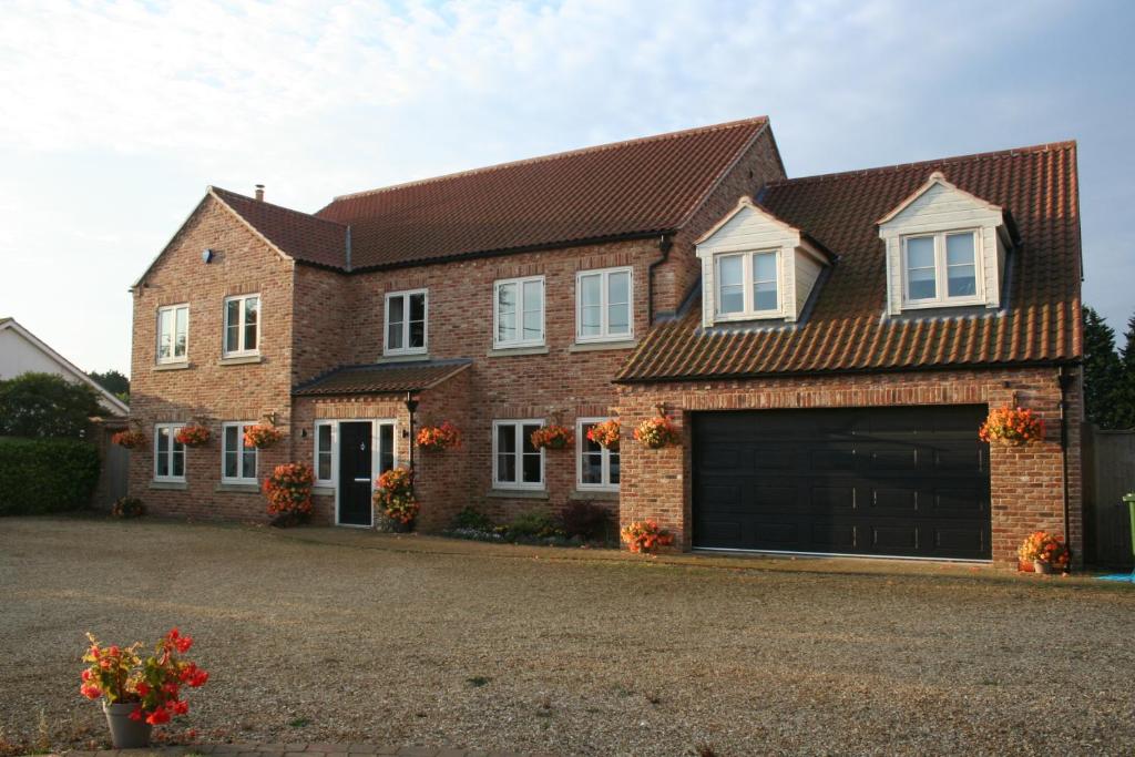 a brick house with a large garage at Labbadax House in Wisbech