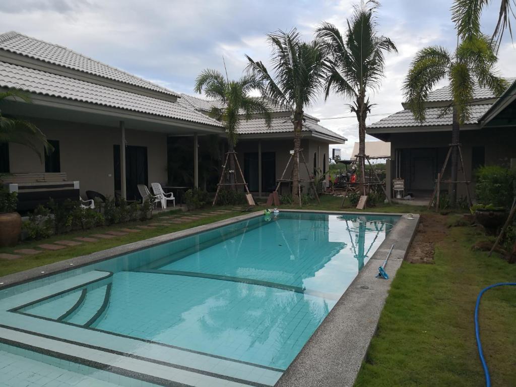 a swimming pool in front of a house at Tropical House​ in Hua Hin