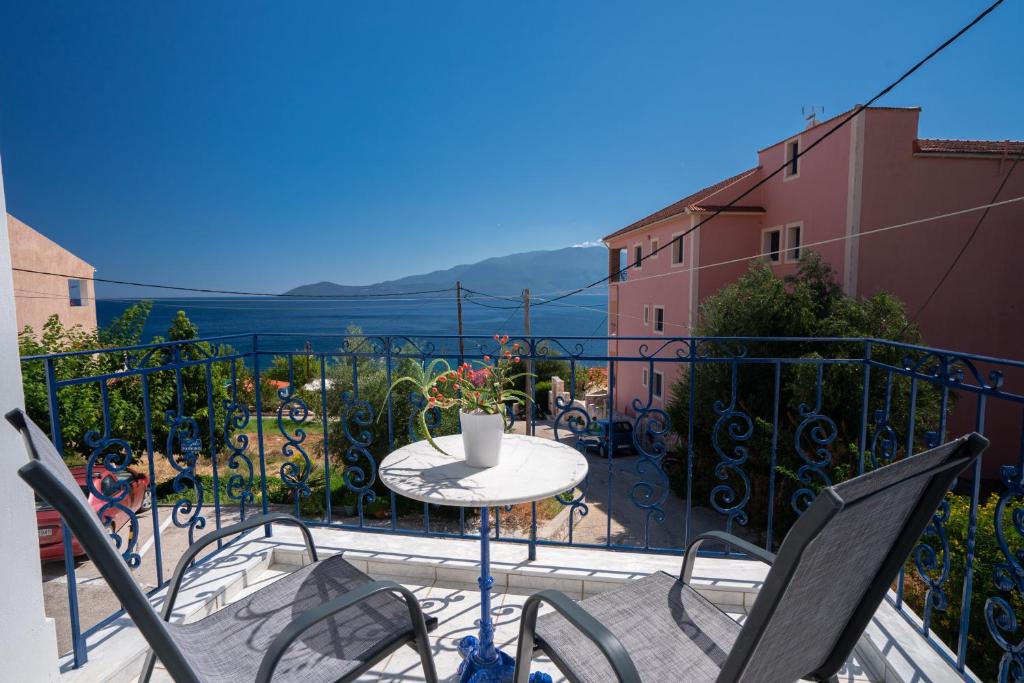 a balcony with a table and chairs on a balcony at Myrto Apartments in Agia Effimia