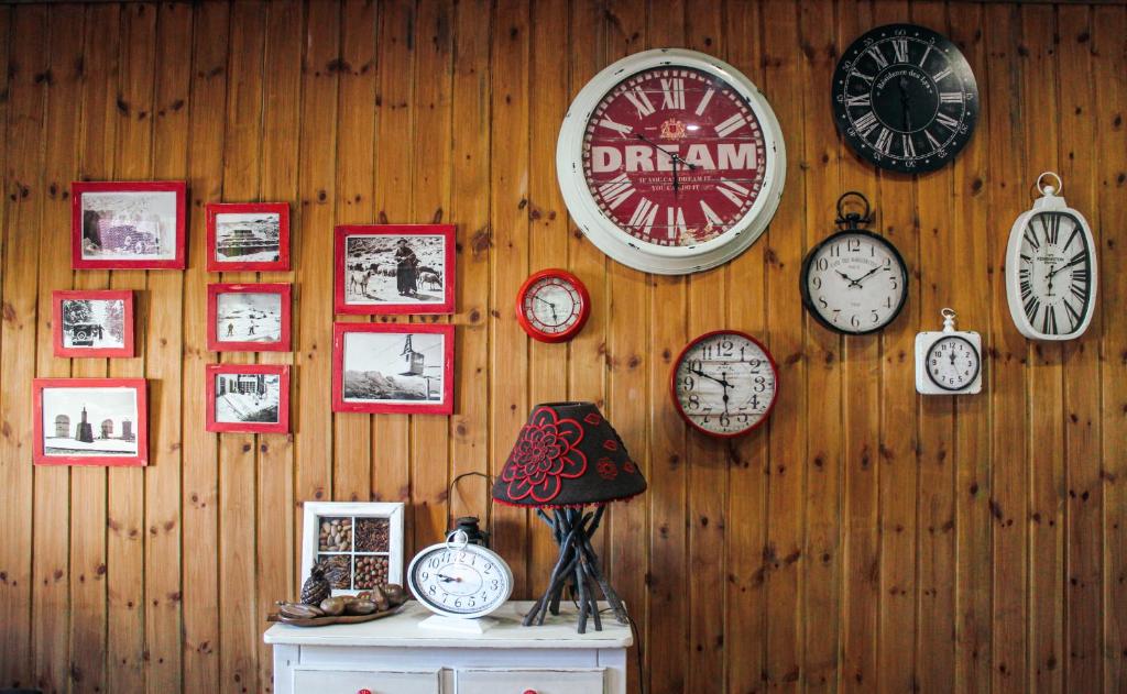 a wall with clocks on a wooden wall at Casinha dos Relógios in Penhas da Saúde