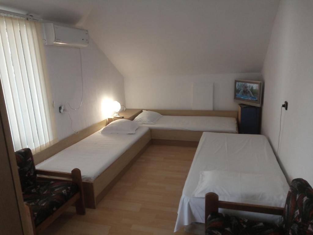Habitación con 2 camas y una silla. en Apartment Friends, en Sandanski
