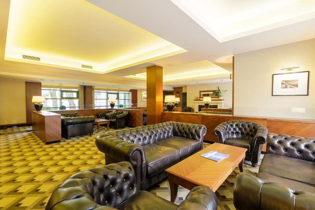a waiting room with leather couches and tables at Meridian Luxury Apartments by Grand Apartments in Sopot