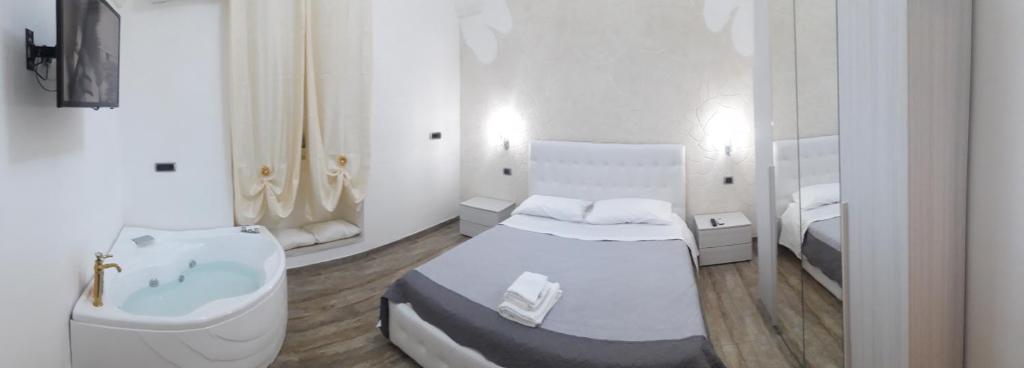 een badkamer met een bad, een bed en een wastafel bij SOLE E LUNA in Taranto