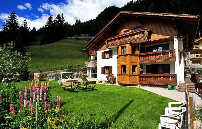 a large house with a yard with a picnic table at Cesa Roseda in Canazei