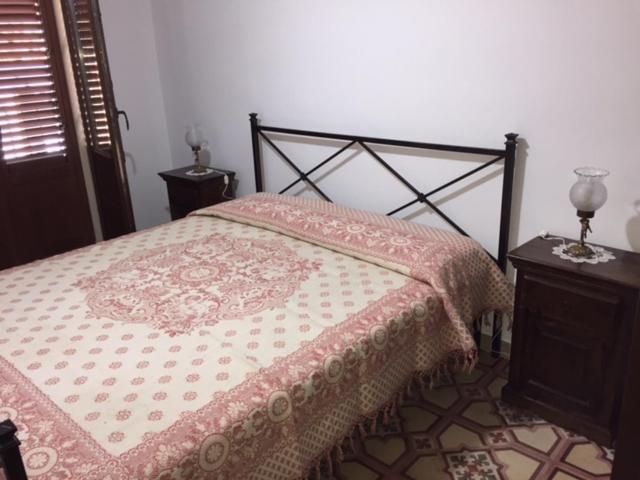 - une chambre avec un lit et une couette rose dans l'établissement Casa Levante, à Castelbuono