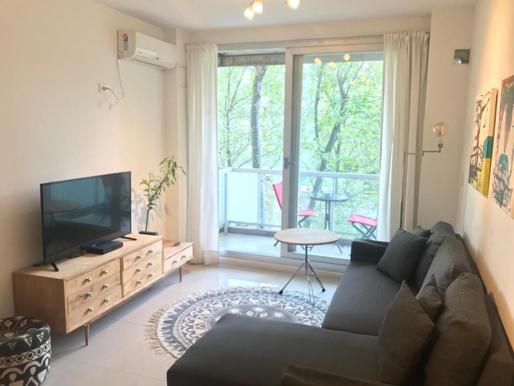a living room with a couch and a flat screen tv at City Park Buenos Aires in Buenos Aires