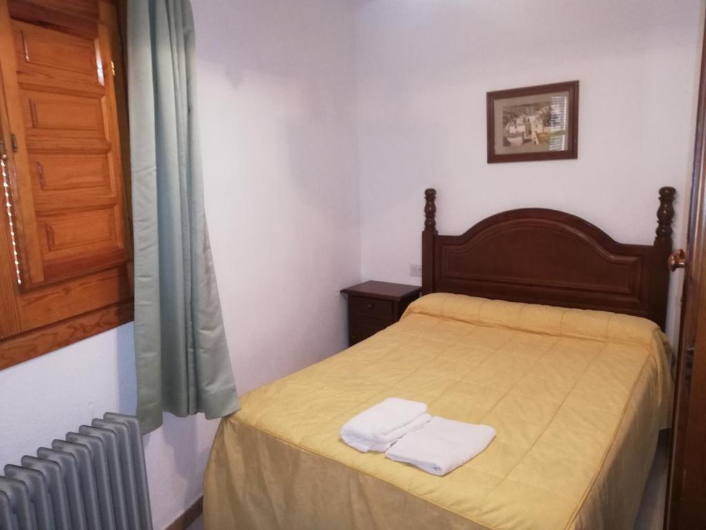 a bedroom with a bed with two towels on it at Apartamentos Cerro Negro in Capileira