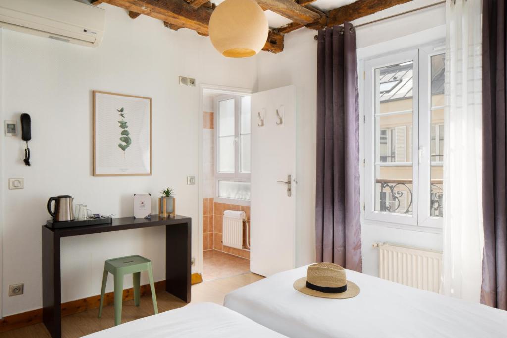 a room with a bed and a table and a stool at Le Village Montmartre by Hiphophostels in Paris