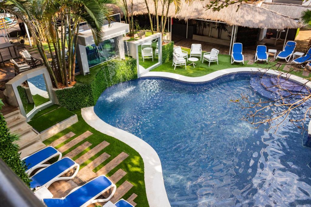 an overhead view of a swimming pool with blue lounge chairs at Los Alpes Santa Teresa in Asuncion