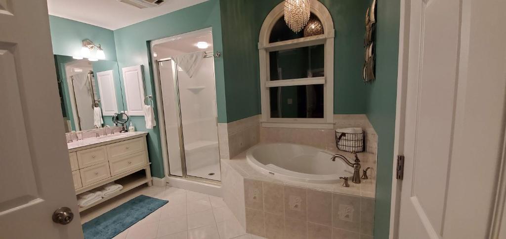 a bathroom with a tub and a sink and a mirror at Mansion Farm Inn in Milton