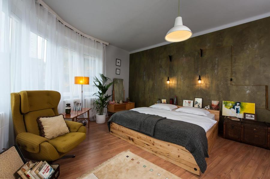 een slaapkamer met een groot bed en een stoel bij Europe Heart Apartment for 9 in Boedapest