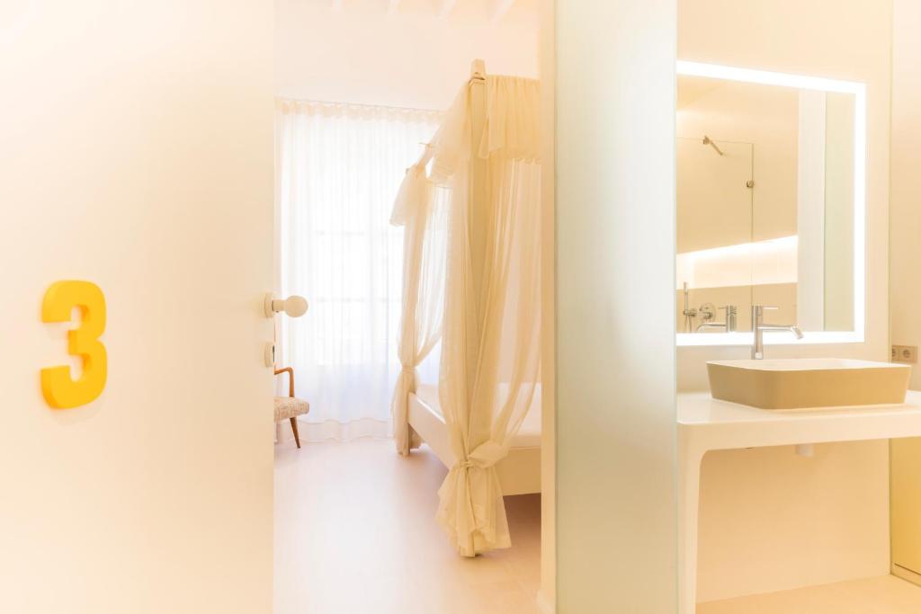 a white bathroom with a sink and a mirror at Fonda Llabres Boutique in Alcudia