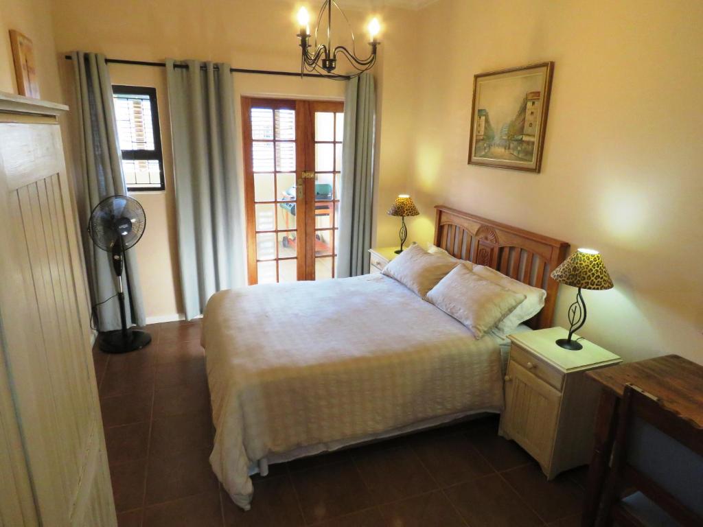 Un dormitorio con una cama grande y una ventana en Gansbaai Central Accommodation, en Gansbaai