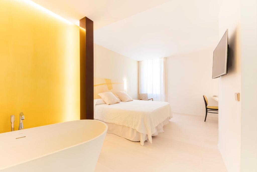 a bathroom with a bed and a bath tub in a room at Fonda Llabres Boutique in Alcudia