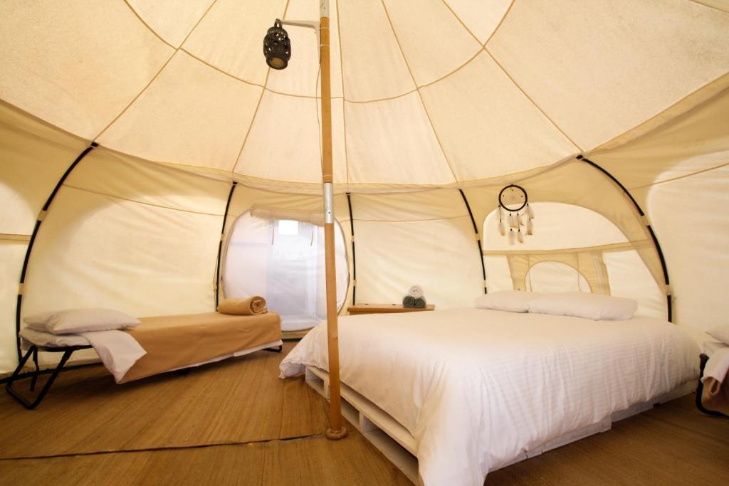 Tendo Glamping في تيبوزتلان: غرفة نوم بسرير في خيمة